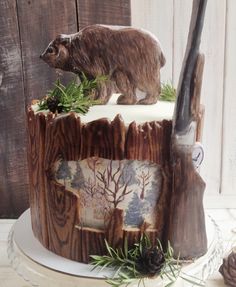 there is a cake with a bear on it and pine cones next to it,