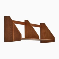 a wooden shelf with two triangular shaped shelves on it's sides, against a white background