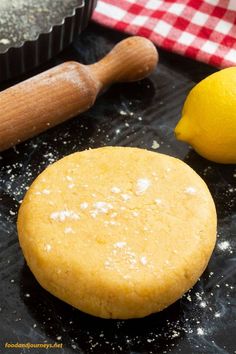 a cookie sitting on top of a baking pan next to a lemon and a rolling pin