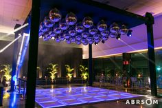 a dance floor is lit up with blue lights and disco balls hanging from the ceiling