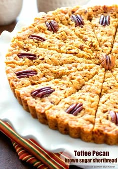 a cake with pecan toppings on a white plate