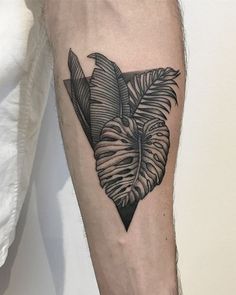 a man's leg with a black and white tattoo design on the left calf