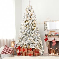 a white christmas tree with presents under it