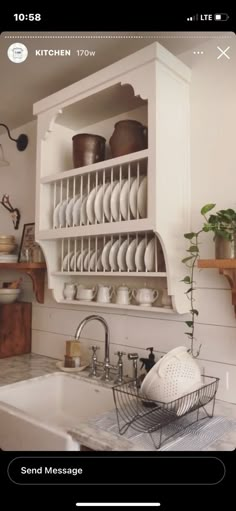 a kitchen with white cupboards filled with dishes