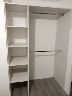 an empty walk in closet with white shelves