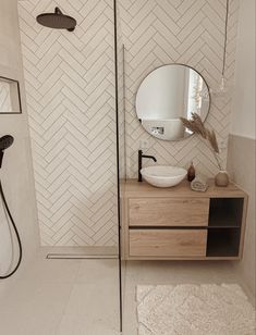 a bathroom with a sink, mirror and shower head on the wall next to it