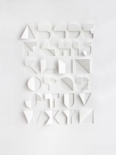 the letters are cut out of paper and placed on top of each other in different shapes