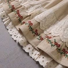 several pieces of cloth with flowers and laces on them, lined up in rows