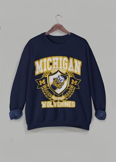 Vintage Michigan Sweatshirt, University of Michigan Crewneck, Retro Varsity Long Sleeve Sweater, Michigan University Wolverines, college football and basketball long sleeve. This is the cutest unisex sweater to wear for any occasion, but especially on game days!  ❇ Colors * Black (with yellow text) * Navy (with yellow text) * White (with blue text) * Gray (with blue text) ❇ The crewneck * 50% cotton (ethically grown in U.S.), 50% polyester * Ribbed knit collar to retain shape * Pre-shrunk * Clas Varsity Outfit, Basketball Long Sleeve, Michigan Sweatshirt, Michigan University, Vintage Michigan, University Sweatshirts, Football And Basketball, University Of Michigan, Michigan Wolverines