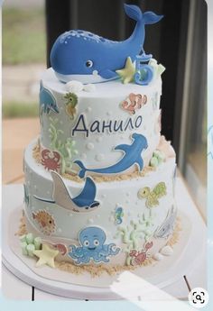 a three tiered cake decorated with an ocean theme and under the sea animals on it