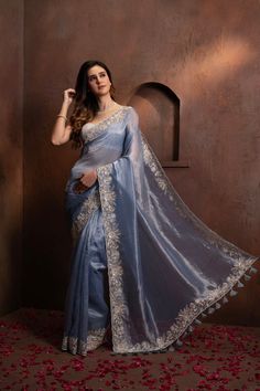 Indulge in the pure luxury of our Hand Embroidered Blue Tissue Organza Saree. Each thread is carefully and meticulously embroidered by hand, creating a one-of-a-kind piece that exudes elegance and sophistication. Elevate your style and make a statement with this exclusive saree. SKU: 0005 Luxury Tissue Silk Saree With Motifs, Luxury Chinon Saree With Chikankari Embroidery, Elegant Blue Embroidered Dola Silk Fabric, Elegant Blue Blouse Piece With Intricate Embroidery, Designer Wear Blue Fabric With Intricate Embroidery, Luxury Embroidered Festive Traditional Wear, Blue Zari Work Embroidered Organza Fabric, Embroidered Light Blue Dupatta For Reception, Blue Art Silk Embroidered Fabric For Designer Wear