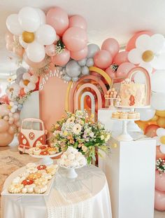 a table topped with lots of desserts and balloons