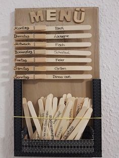 wooden utensils are arranged in a box with the words menu written on them