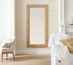 a white couch sitting under a mirror in a living room