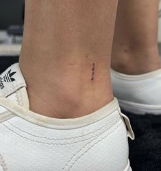 a woman's foot with a small tattoo on the side of her ankle,