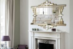 a living room filled with furniture and a fire place under a mirror on the wall