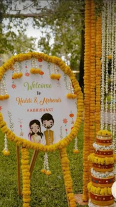 a welcome sign is decorated with flowers and garlands for the couple's wedding