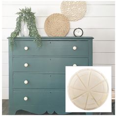 the dresser is painted green and has white knobs on it, along with a plant