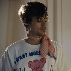 a man wearing a white t - shirt with a pink bear on it's chest