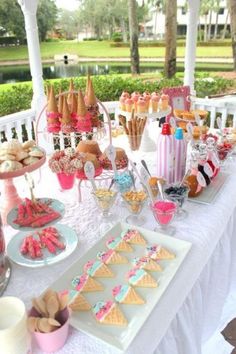 a white table topped with lots of desserts and snacks on top of it's own