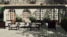 a patio with chairs, tables and potted plants