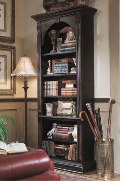 an ornate bookcase with many books and other items on it in a living room