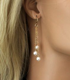 "Sophisticated and Elegant Pearl Earrings that feature beautiful white Swarovski Pearls that gracefully dangle from gold filled chains. The chains are all different lengths making these earrings perfect to add the right touch of elegance to any wedding dress or bridesmaids dress. Each is suspended from gold filled ball french ear wires. [MATERIALS] * High Quality Swarovski Pearls * Dainty 14kt Gold Filled Chain * 14kt Gold Filled Ear Wires These beautiful earrings measure (47mm) 1-7/8\" in lengt Elegant Jewelry With Dangling Charms, Elegant Party Jewelry With Dangling Charms, Dainty Wedding Jewelry With Dangling Charms, Elegant Chandelier Earrings With Adjustable Chain, Chandelier Earrings With Adjustable Chain As Gift, Wedding Linear Dangle Earrings With Beads, Wedding Linear Dangling Bead Earrings, Elegant Linear Earrings With Dangling Beads For Party, Elegant Long Drop Chandelier Earrings With Dangling Charms