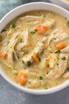 two bowls of chicken and dumpling soup on a table