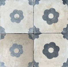 four square tiles with black and white designs on the outside, one has a flower in the middle