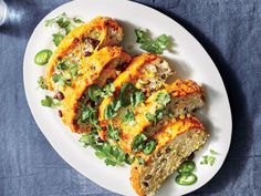 a white plate topped with slices of bread covered in cheese and veggie toppings