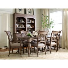 a dining room table and chairs in front of a bookcase