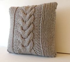 a knitted pillow sitting on top of a white table