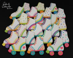 decorated cookies in the shape of roller skates on a black table with white icing