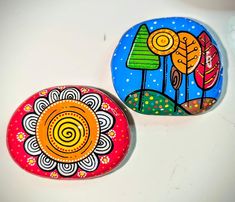 two painted rocks sitting on top of a white table