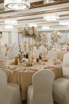 the tables are set with white chairs and gold tablecloths for an elegant wedding reception