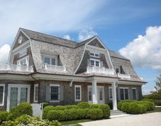 a large house with many windows and bushes