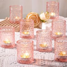 there are many pink glass cups on the table