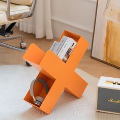 an orange book stand sitting on top of a white rug in front of a chair