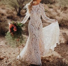 a woman in a white dress is walking through the desert with her hand on her hip