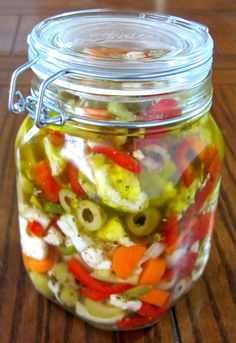 a glass jar filled with pickles and peppers