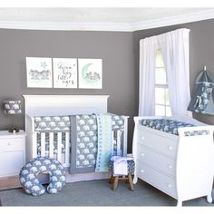 a baby's room with gray walls and white furniture