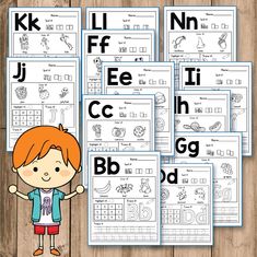 the alphabet worksheets are set up on a wooden table with two children standing in front of them