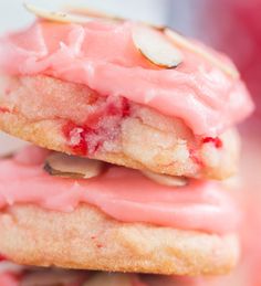 three pink frosted cookies stacked on top of each other