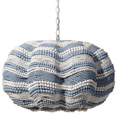 a blue and white beaded purse hanging from a metal chain on a white background