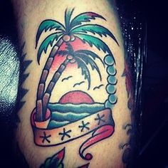 a tattoo with a palm tree and ribbon on the side of someone's leg