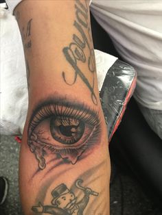 a close up of a person's arm with an eye tattoo