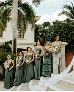 a group of women standing next to each other in front of a building with palm trees