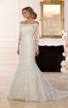 a woman in a white wedding dress standing on a tile floor next to a mirror