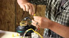 a man working on an electronic device with wires attached to the back of his arm