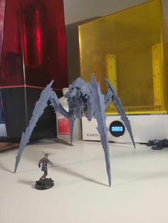 an image of a toy figure on a desk with other toys in the back ground